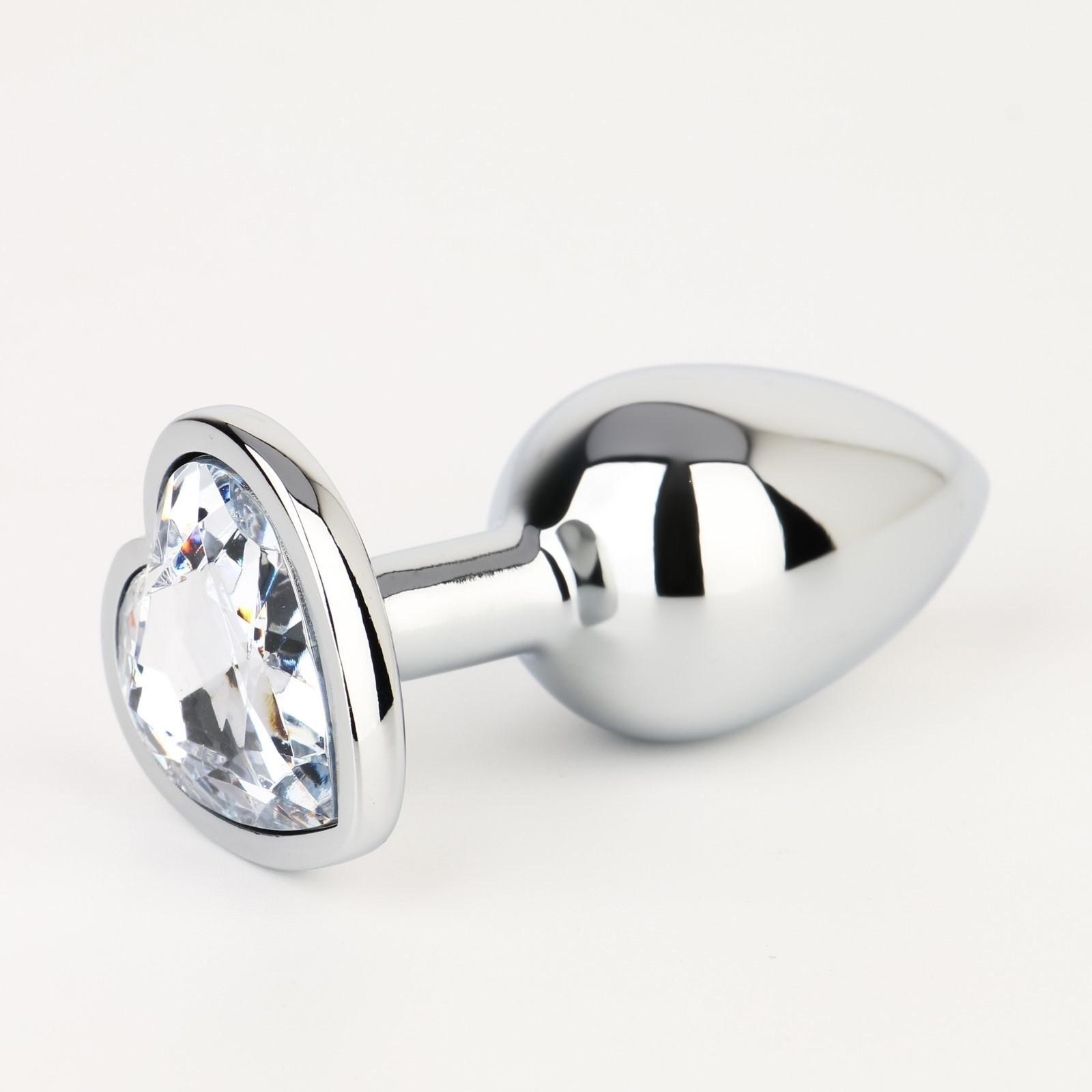 Серебристая анальная пробка с прозрачным кристаллом в форме сердца - 7 см.
